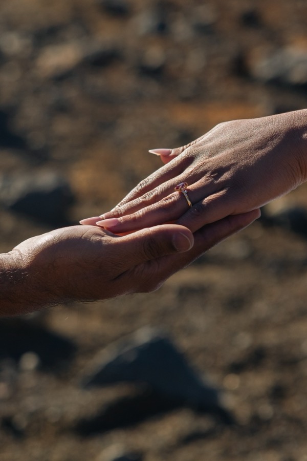 Ankita's hand resting in Aditya's, wearing her engagement ring